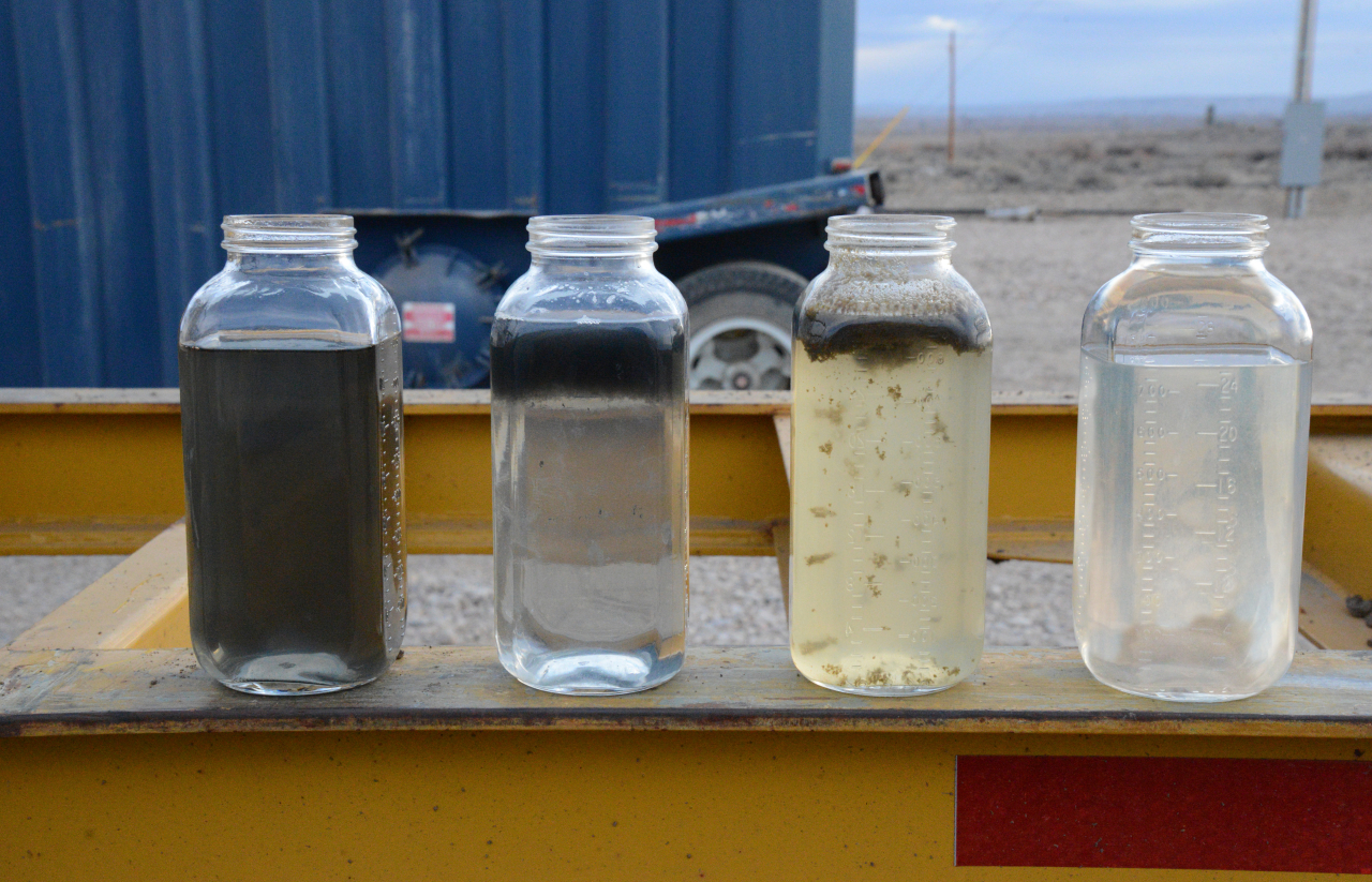 Смесь нефтепродуктов. Стеклянные бутылки для отбора проб нефтепродуктов. Расслоение жидкости. Пробы загрязненной воды. Примеси в воде.